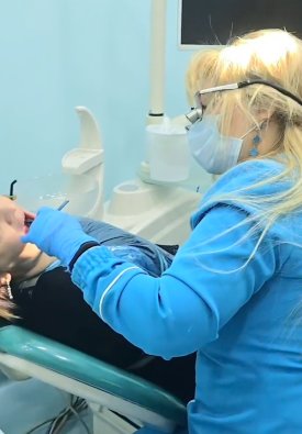 Şəlalə Əhmədova böyüdücü optika ilə xəstəni müalicə edir